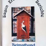 Foto, weißes Buch-Cover, Titel oben im Halbkreis, darunter ein Foto von der Storchentafel an der Kirche des Dorfes, darunter in blauer Schrift: Heimatbund Dollbergen.