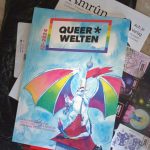 Foto, frisch aus dem PostUmschlag, ein handliches Buch. Auf dem Cover ein Drache mit RegenbogenFlügeln.